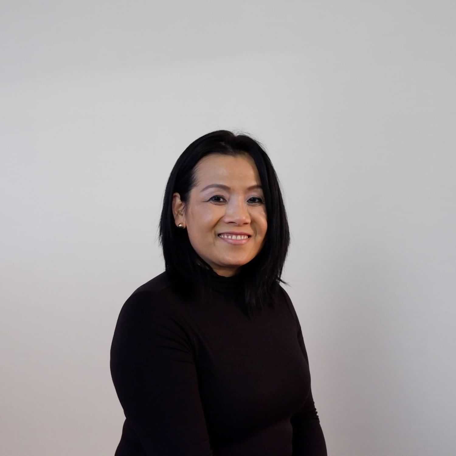 Portrait of Tunhi H, a professional stylist at Design 1 Salon & Spa, showcasing their expertise and style.