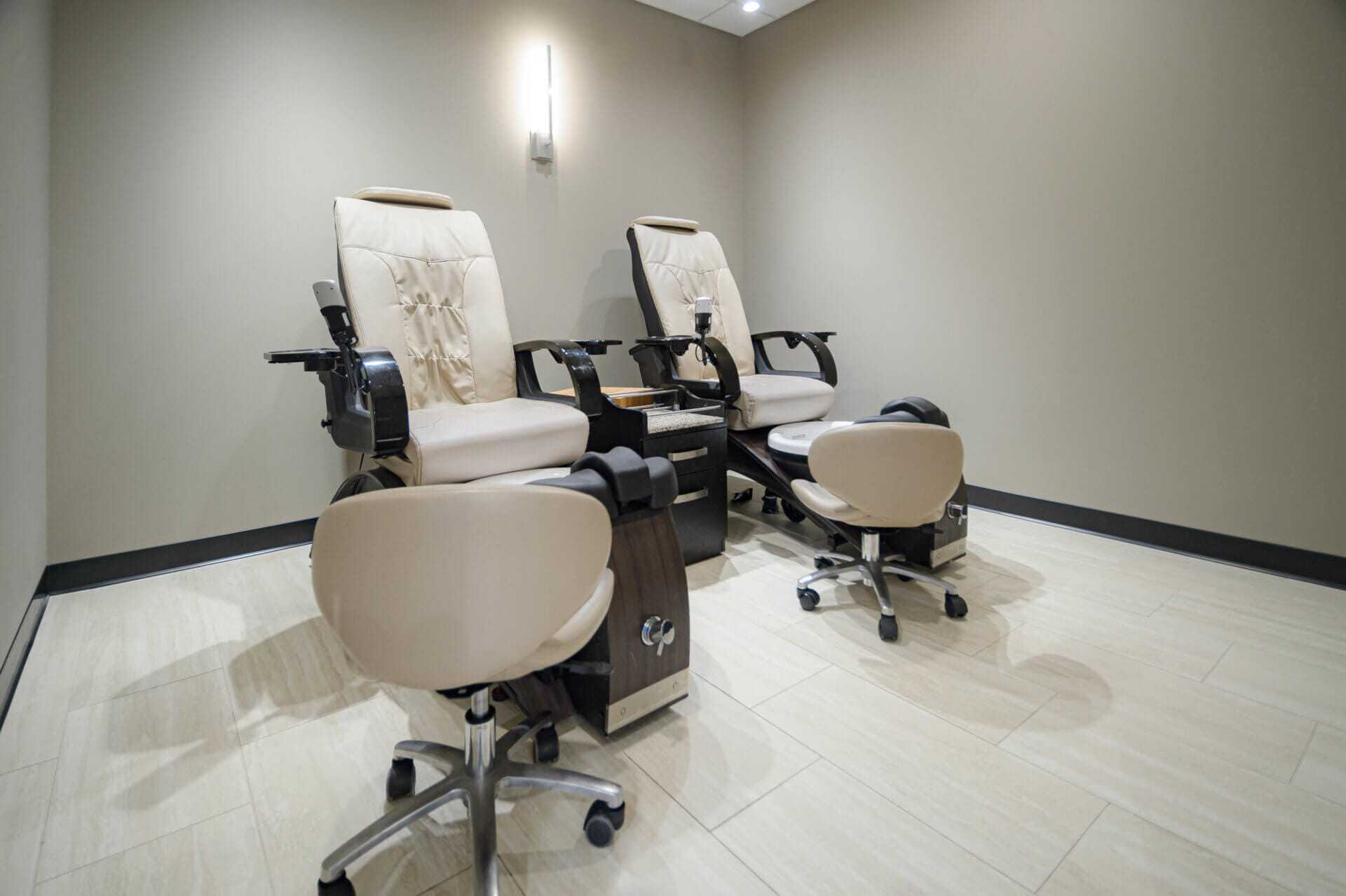 Nail salon with two cushioned pedicure chairs and foot spa stations.
