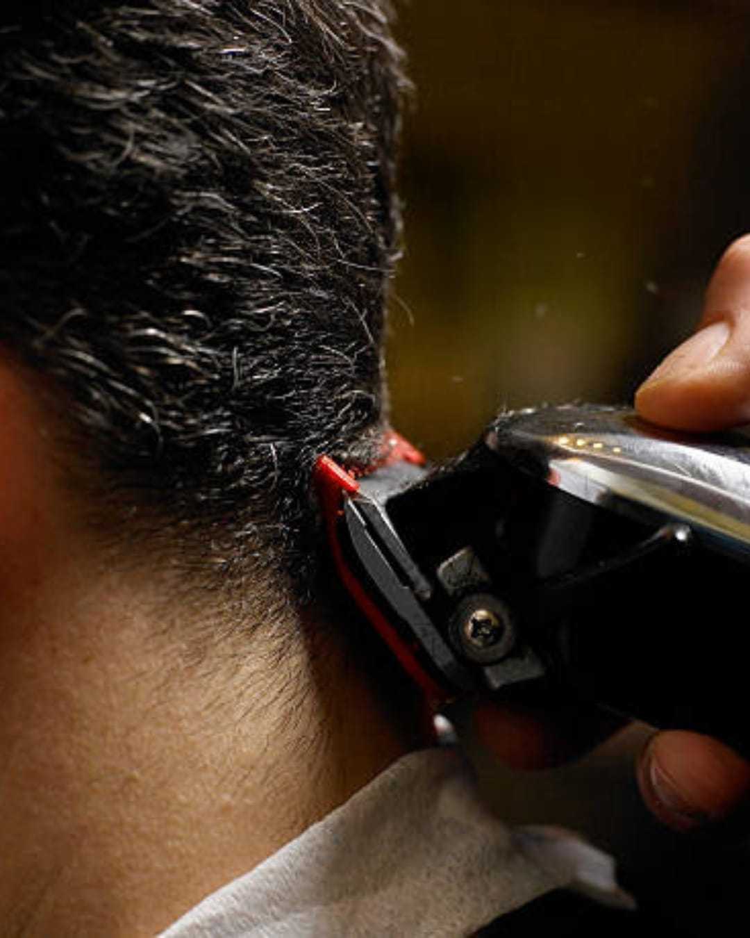Hair being trimmed with electric clippers at the nape of the neck.